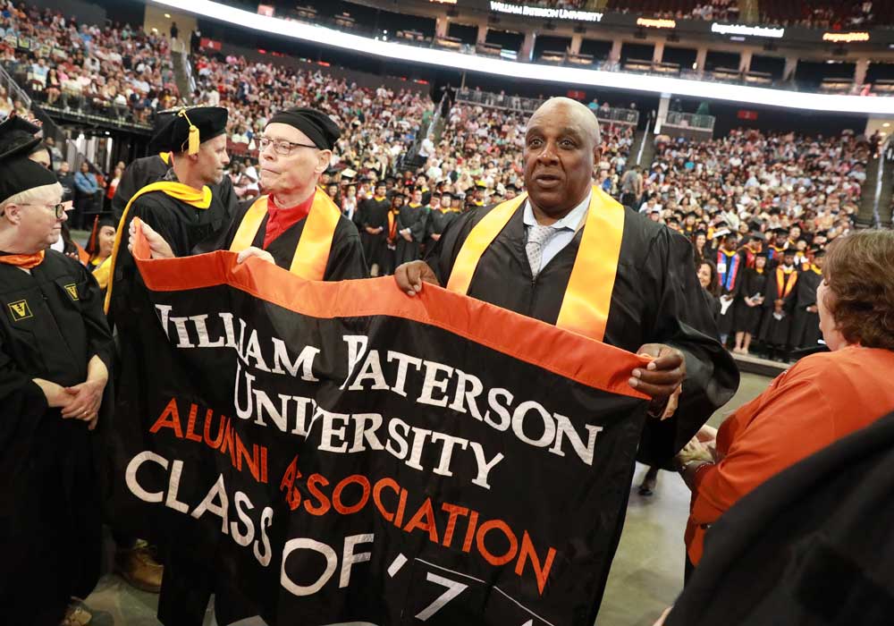 Charles Hawthorne and Steve Brown carry the Class of 1974 banner